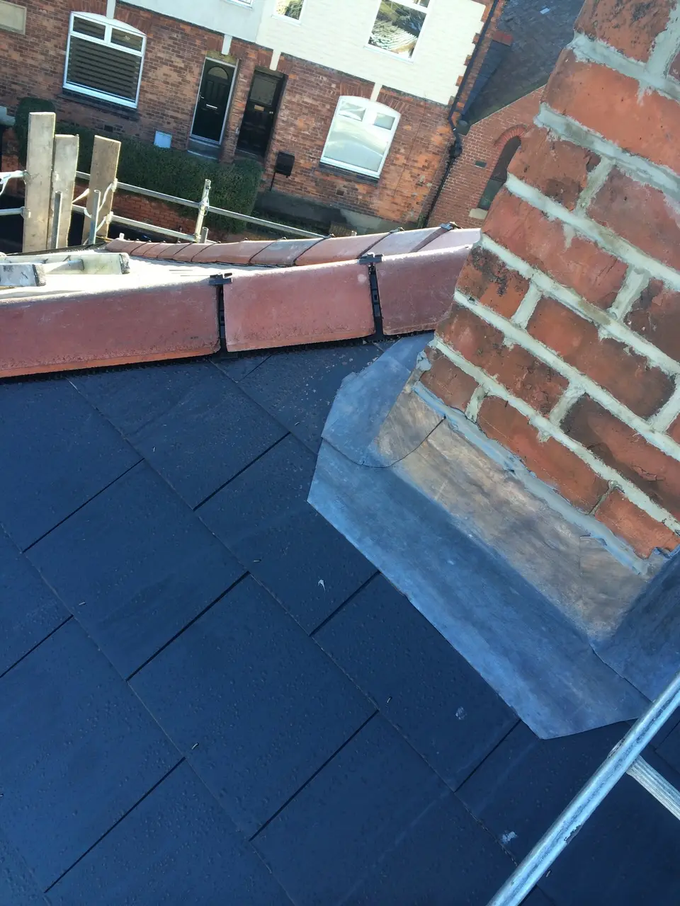 Slate roof with chimney leadwork and ridge tiles